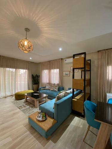 a living room with a blue couch and a table at Villa La Gospa in Libreville