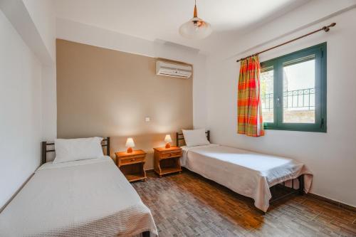 a room with two beds and a window at Metochi Villas in Spílion