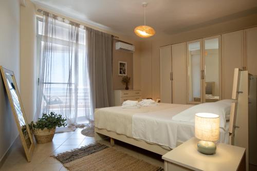 a bedroom with a white bed and a window at Fole Maison in Durrës