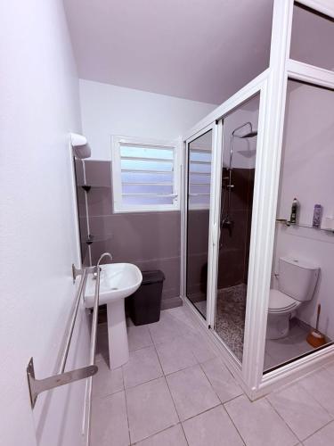 a bathroom with a shower and a toilet and a sink at Le Petit Refuge in Cayenne