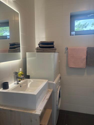 a white bathroom with a sink and a mirror at Romantic beach cottage in Kalana