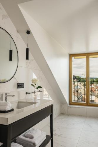 a white bathroom with a sink and a window at Beau-Rivage Nyon in Nyon