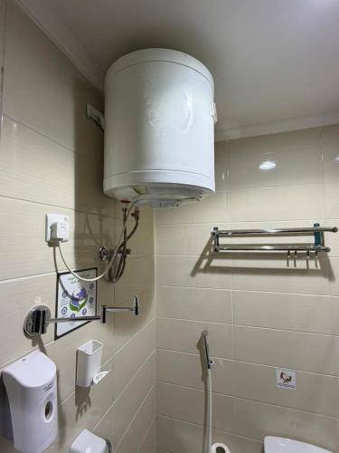 a bathroom with a toilet and a light on the wall at Al Maqam Alsharqy Shuttle Srevice to Haram in Mecca