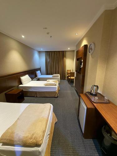 a hotel room with two beds and a television at Al Maqam Alsharqy Shuttle Srevice to Haram in Mecca