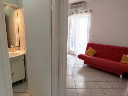 a red couch in a living room with a window at Apartment Mila in Primošten