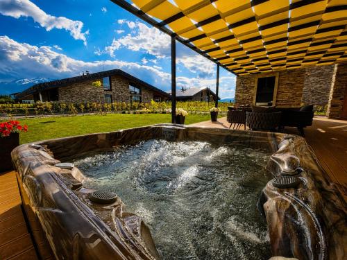 a hot tub in a yard with a patio at Hypnotic Thermal Villas with private SPA in Banya