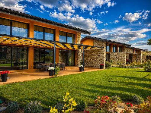 a house with a patio and a lawn at Hypnotic Thermal Villas with private SPA in Banya