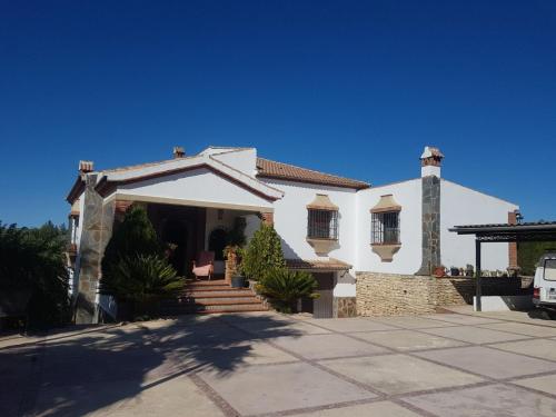 a white house with a porch and stairs at Charming house in Arriate with private pool. in Arriate