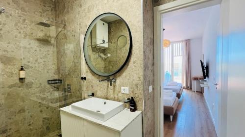 a bathroom with a sink and a mirror on the wall at Veranda Apartment, Green Coast in Palasë