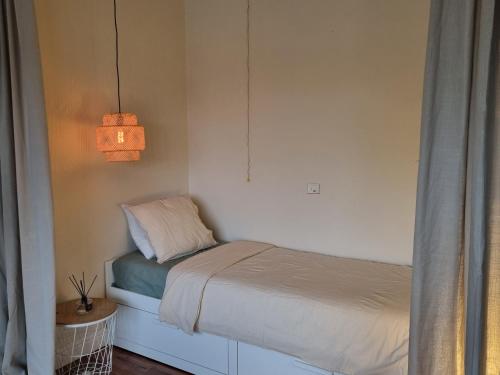 a small bed in a bedroom with a lamp at Ghent Business Flat in Ghent