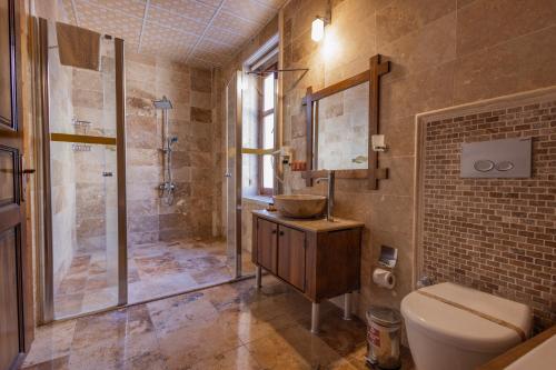 a bathroom with a sink and a shower and a toilet at Grand Cappadocia Hotel in Göreme