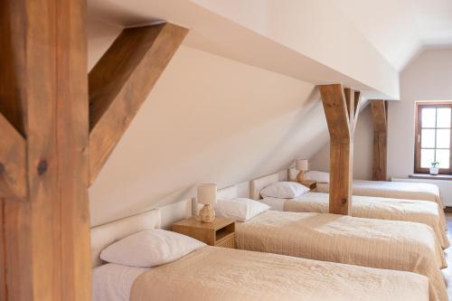 three beds in a attic room with wooden beams at Krępianka in Sandomierz