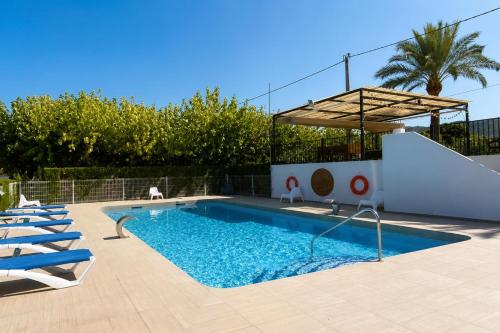 a swimming pool with a slide and some chairs at Kampaoh Playa de Levante in Benidorm