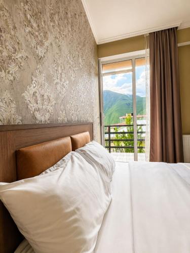 a bedroom with a white bed and a window at Sky Star in Kazbegi