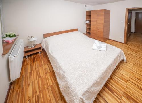 a bedroom with a bed and a wooden floor at Zawoja1560 Apartamenty przy Aptece in Zawoja