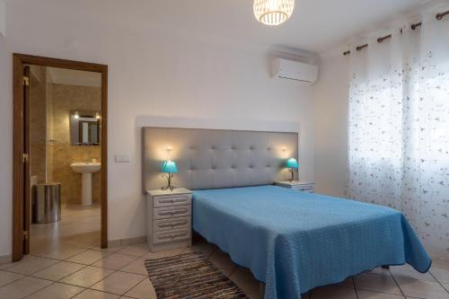 una camera con letto blu e un bagno di Akivillas Albufeira Golden ad Albufeira