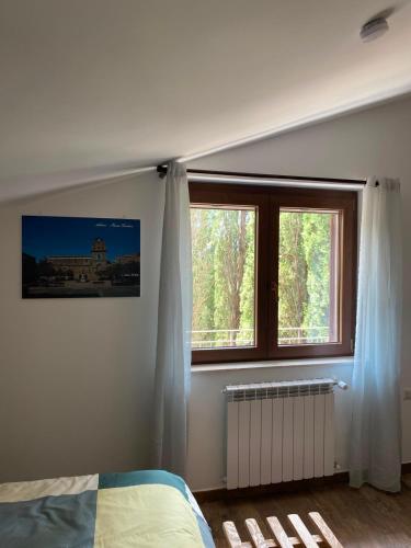 a bedroom with a bed and two windows at Fuga dalla città in Aidone