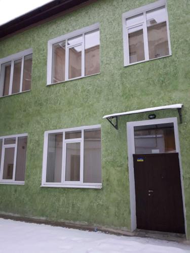 a green building with a door and windows at Смарт-апартаменти " Lutskyj zamok" in Luts'k
