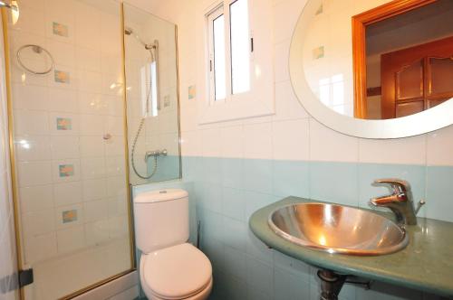 uma casa de banho com um lavatório, um WC e um espelho. em HomeHolidaysRentals Aqua em Santa Susanna