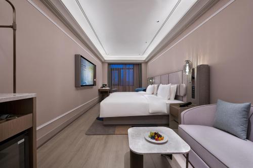 a hotel room with a bed and a couch at Mercure Beijing Lize Road in Beijing