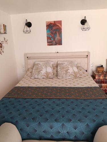 a bed in a bedroom with a blue mattress at L'océane in Saint-Maurice-de-Beynost