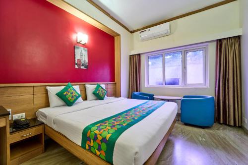 a bedroom with a large bed and a red wall at Treebo ESS Grande in Coimbatore