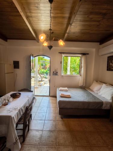 a bedroom with two beds and a table and chairs at Sofia Apartments- Melidoni in Melidhónion