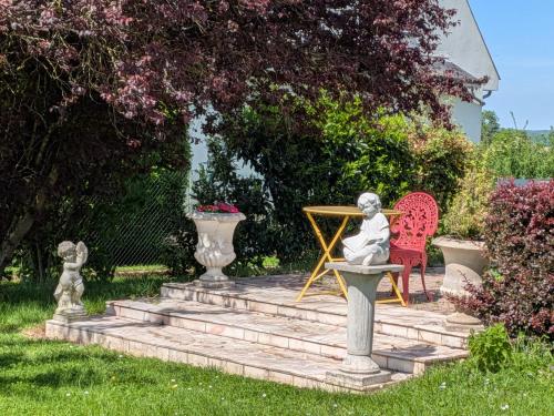 a statue of a woman sitting on a chair in a garden at Gîte des Lilas in Stenay