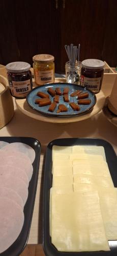 a table with two trays of cheese and a plate of food at Lavanda Termas de São Pedro do Sul in Termas de Sao Pedro do Sul