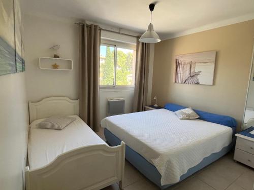 a bedroom with two beds and a window at 50 pas de l'Ô in Saint-Cyr-sur-Mer