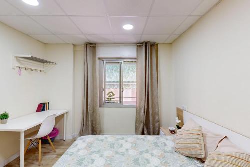 a bedroom with a bed and a desk and a window at Apartamento Céntrico en Murcia in Murcia