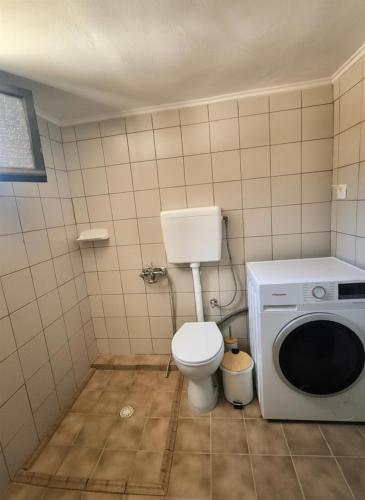 a bathroom with a toilet and a washing machine at Sofia Apartments- Melidoni in Melidhónion