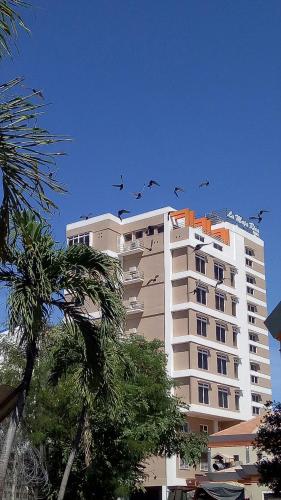 a flock of birds flying over a building at La Maja Rica Hotel in Tarlac