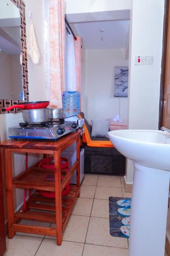 a kitchen with a counter with pots and pans on a table at Manta homes studio Apartments in Thika