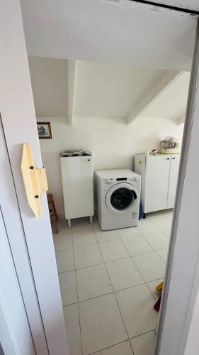 a kitchen with a microwave and a washing machine at Linoq in Montepagano
