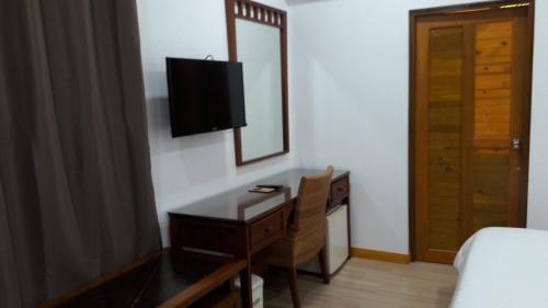 a bedroom with a desk with a television and a bed at Holiday Garden Rasdhoo in Rasdu