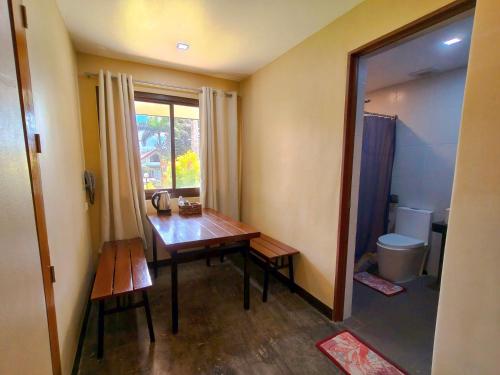 a small room with a wooden table and a toilet at Pina Colina Resort Tagaytay City by RedDoorz in Tagaytay