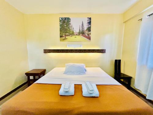 a bedroom with a bed with two towels on it at Pina Colina Resort Tagaytay City by RedDoorz in Tagaytay
