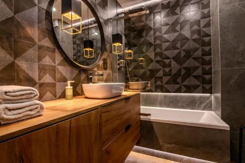 a bathroom with a sink and a mirror and a tub at Apartament 20 in Mysłowice