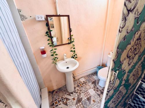 a bathroom with a sink and a mirror and a toilet at La española in Santo Domingo