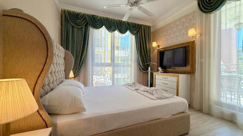 a bedroom with a bed and a tv and a window at Bratanov Harmony Monte Carlo in Sunny Beach
