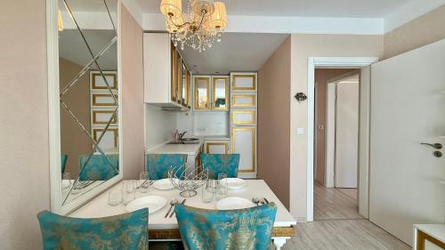 a dining room with a table and blue chairs at Bratanov Harmony Monte Carlo in Sunny Beach
