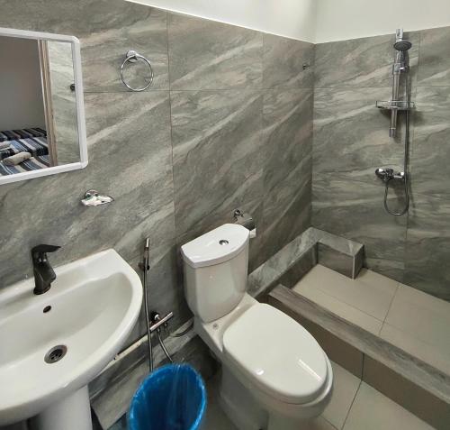 a bathroom with a white toilet and a sink at Mountview Tourist Residence in Quatre Bornes