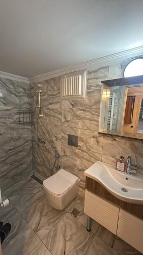 a bathroom with a toilet and a sink and a mirror at Valoria Hotel in Uzungöl
