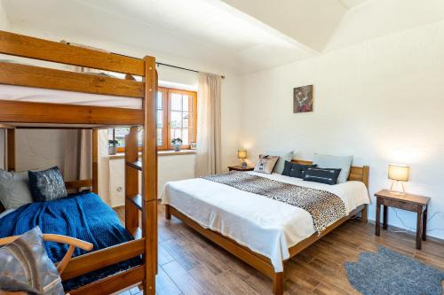 a bedroom with a bed and a bunk bed at WELLNESS FARMHOUSE Monínec in Měšetice