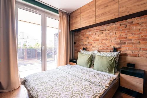 a bedroom with a brick wall and a bed at Apartament 20 in Mysłowice