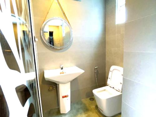 a bathroom with a sink and a toilet and a mirror at The Mulberry Villa kandy in Kandy