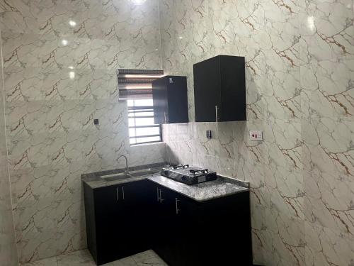 a kitchen with a sink and a counter top at Universal Apartment & Suites in Ibadan