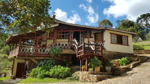 a house with a balcony in front of it at Pousada Meu Recanto in Conceição da Ibitipoca