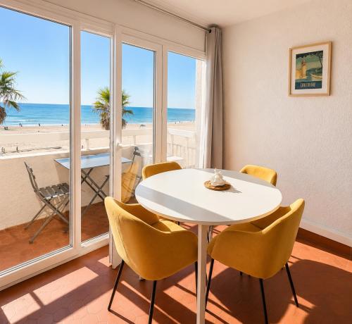 a dining room with a table and chairs and the beach at ROSEVA - T2 Vue mer - Plage à pied - Balcon - Climatisation in Canet-en-Roussillon